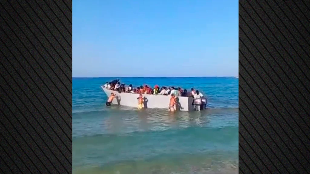 Λουόμενοι σπρώχνουν βάρκα με μετανάστες που φτάνουν στη Γαύδο (Video)